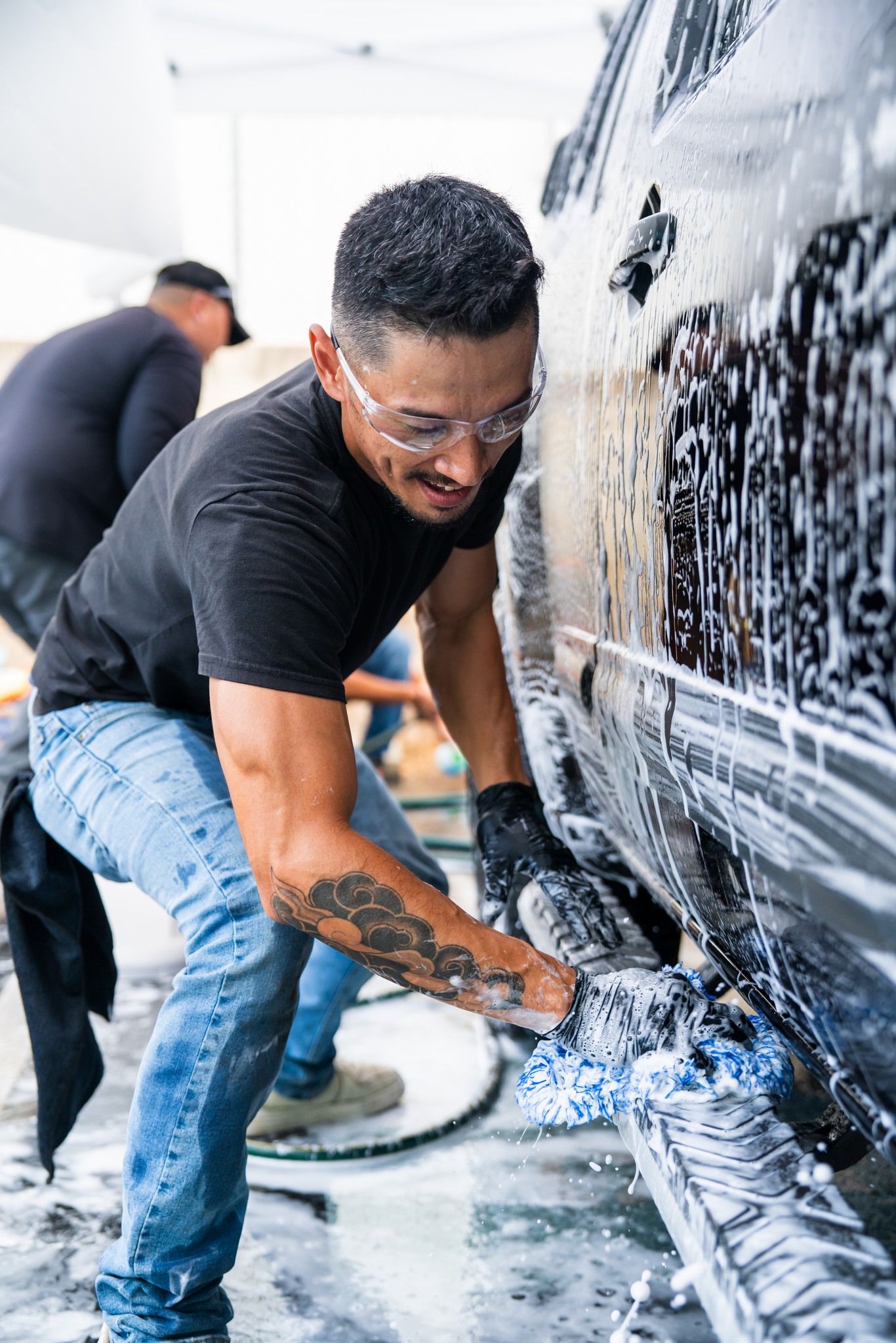 808 Auto Detail team member performing a professional foam bath on a vehicle